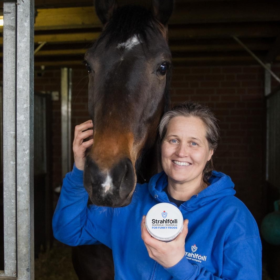 Farrier Aletia Reilingh with a horse, holding a tub of Strahlfoili